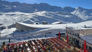 A snow-covered mountain landscape with a ski resort and a restaurant with outdoor seating. - Modern apartment for 12 with wifi, in the heart of Val Thorens (Val Thorens)