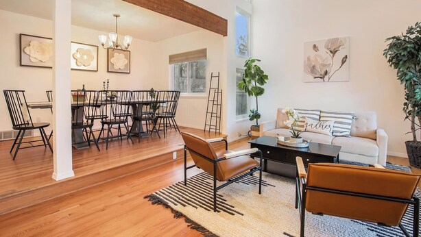 A spacious living room with a dining area, wooden floors, and modern furniture.