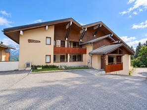 A two-story building with a wooden facade, a sign reading 'La Sapiniere B.', and a parking area in front. - Cozy duplex for 5 near slopes with parking at Espace Diamant (Cohennoz)
