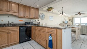 A spacious kitchen with wooden cabinets, a dishwasher, and a large island.