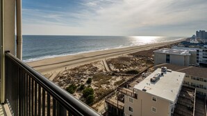A balcony with a view of a beach and ocean.