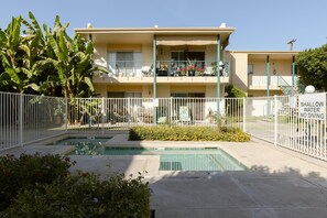 A two-story building with a swimming pool and a fenced area. - Modern Chic Condo In Midtown w/ Pool & Hot Tub (Phoenix)