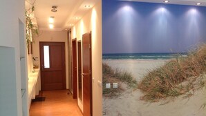 Un couloir avec des portes en bois et une vue sur une plage la nuit.