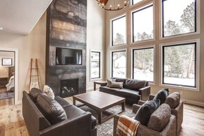 A spacious living room with a fireplace, large windows, and a modern design. - The Juniper (Lead)