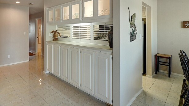 A kitchen with white cabinets, a countertop, and a decorative bird sculpture. - Dock Holiday 2 Bedroom Condo by Redawning (Rockport)