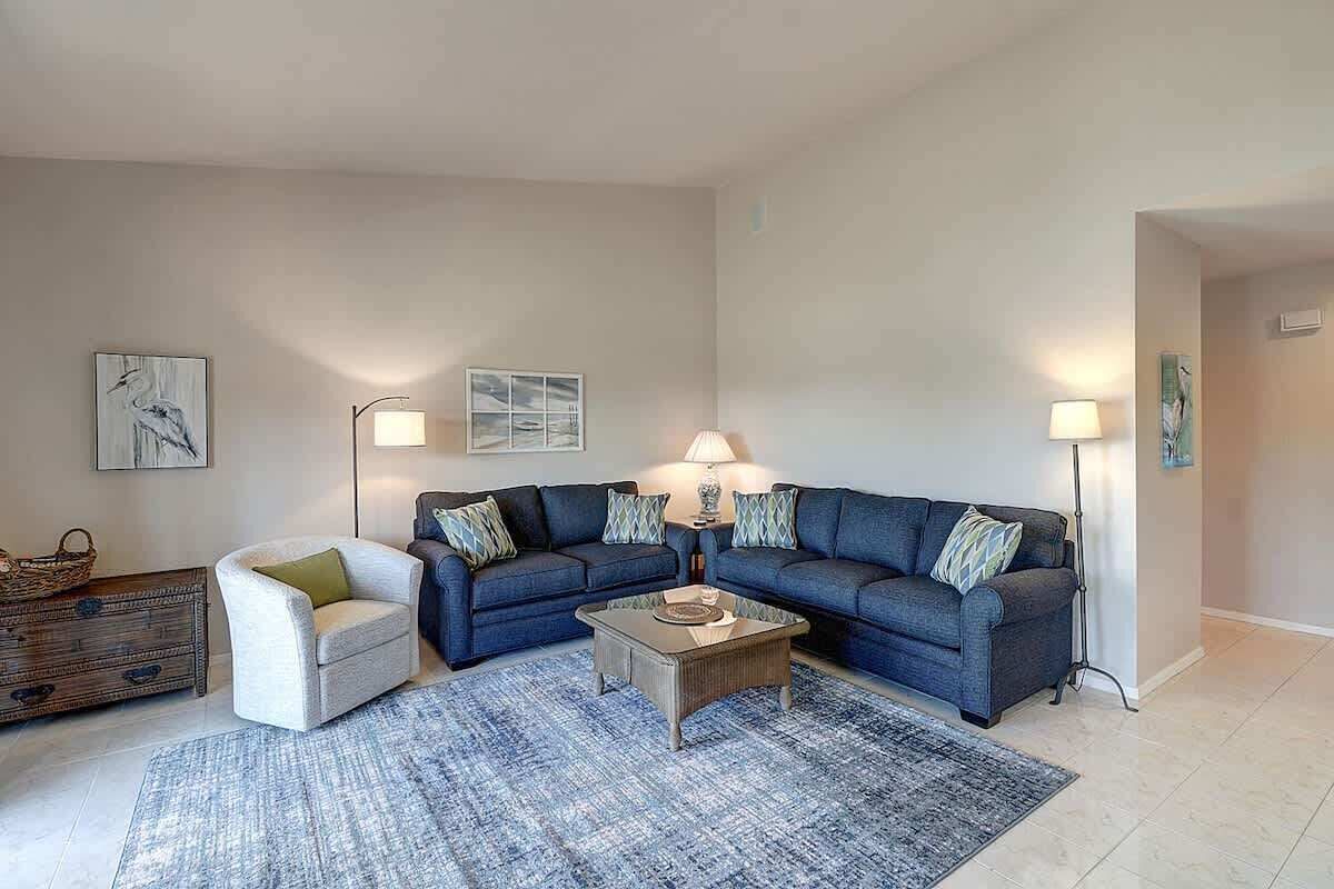 A living room with a sofa set, a coffee table, a side chair, and two floor lamps.