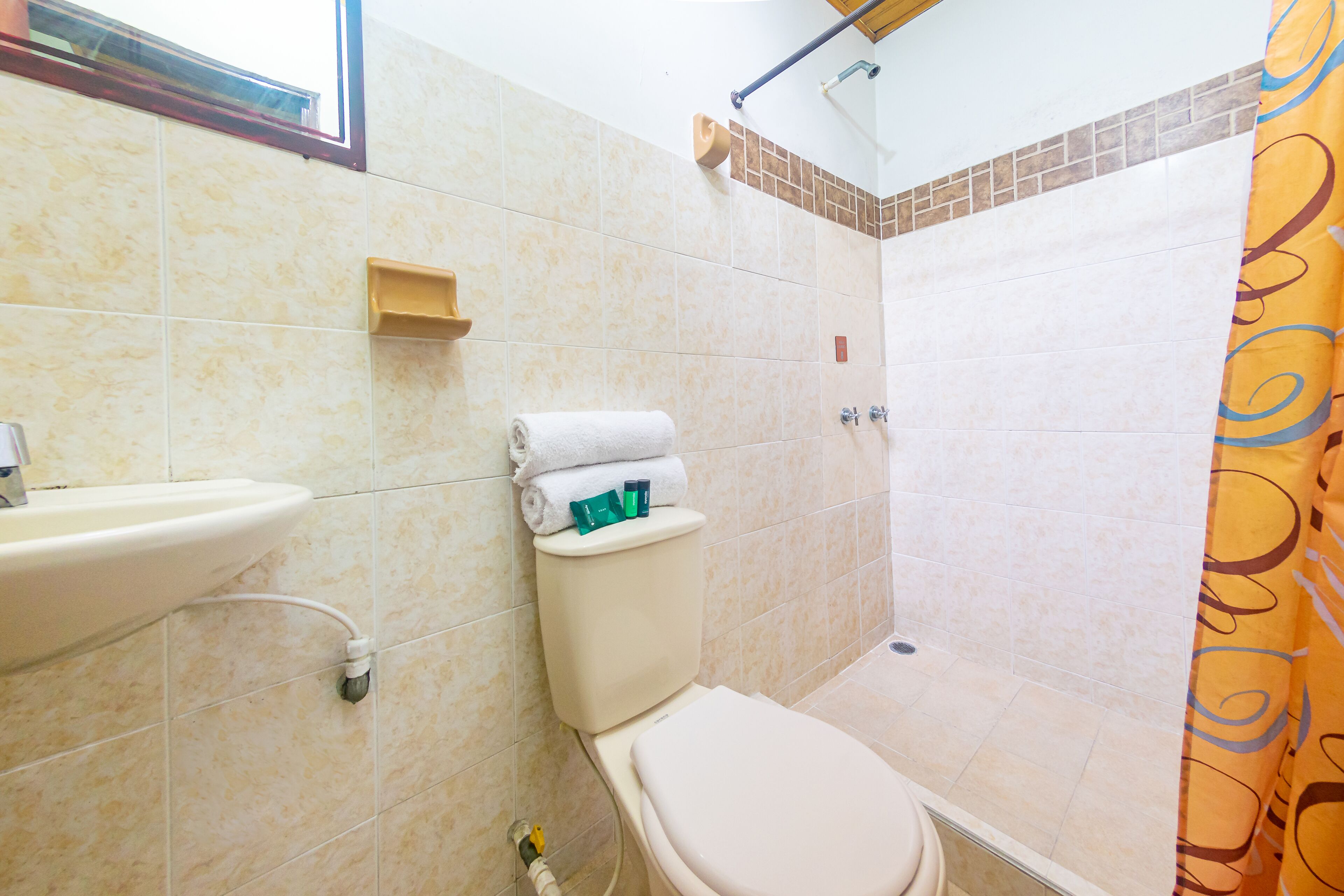 Un baño con inodoro, lavamanos y ducha.