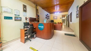 A hotel reception area with a wooden reception desk, a computer, and a sign that reads "ayenda HOTELS". - Ayenda Pakande (Popayán)