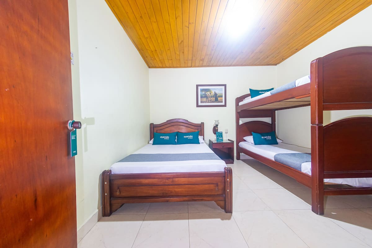 A room with a wooden bed, a bunk bed, and a wooden ceiling.
