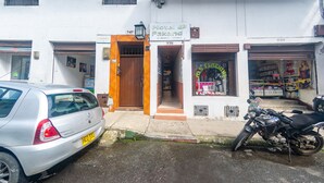 A white building with a sign for Hotel Pakand, a Renault car parked in front, and a motorcycle to the right. - Ayenda Pakande (Popayán)