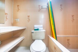 Un baño con inodoro, lavamanos y zona de ducha.