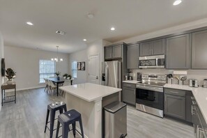 Enjoy cooking in this well-equipped kitchen with a central island, stainless steel appliances, and ample counter space.