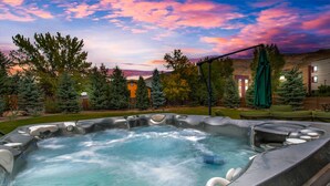 Un jacuzzi dans un jardin, avec vue sur les maisons et les arbres.