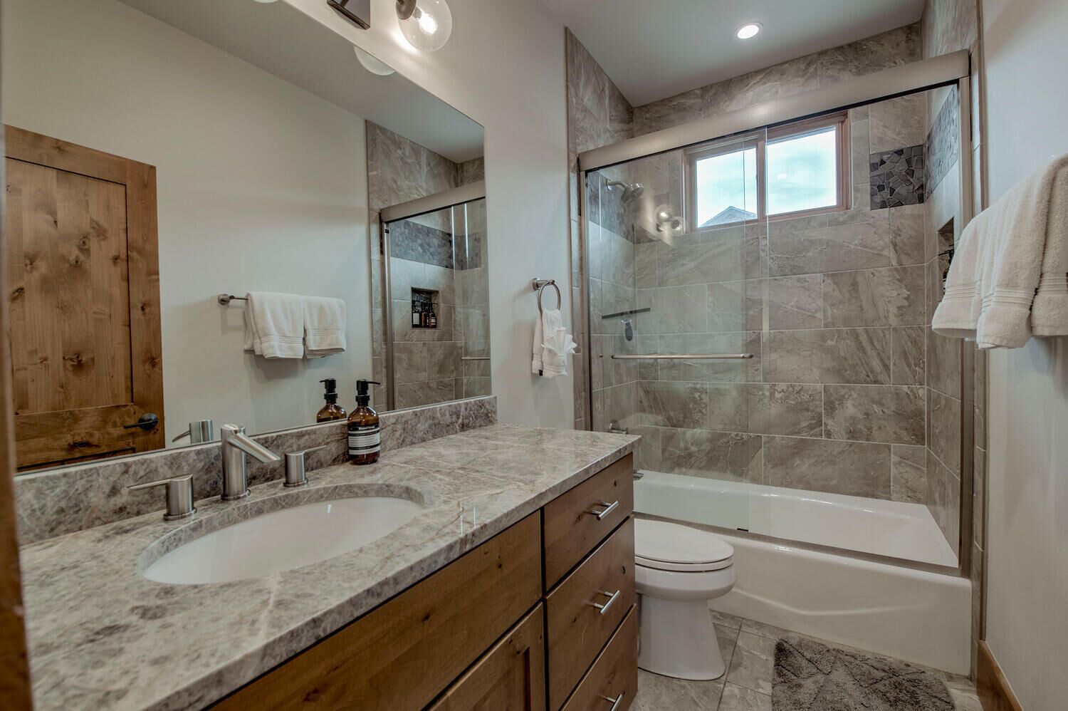 Un baño moderno con tocador de doble lavamanos, cabina de ducha de vidrio, inodoro y bañera.