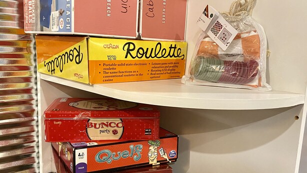 A shelf with various board games and a dice set. - Peaceful river front cabin in the WOODS! Kayak, snowmobile, hike, relax! (Rhinelander)
