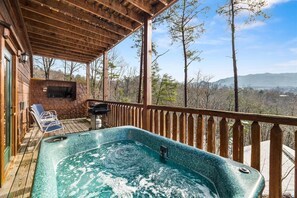 A hot tub on a wooden deck with a view of trees and mountains. - HOT TUB & VIEW - Grand Views & Entertainment Galore, Fall & Winter SPECIALS!! (Gatlinburg)