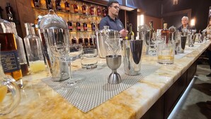 Eine Bar mit einer langen Theke, auf der verschiedene Gläser und Flaschen ausgestellt sind.