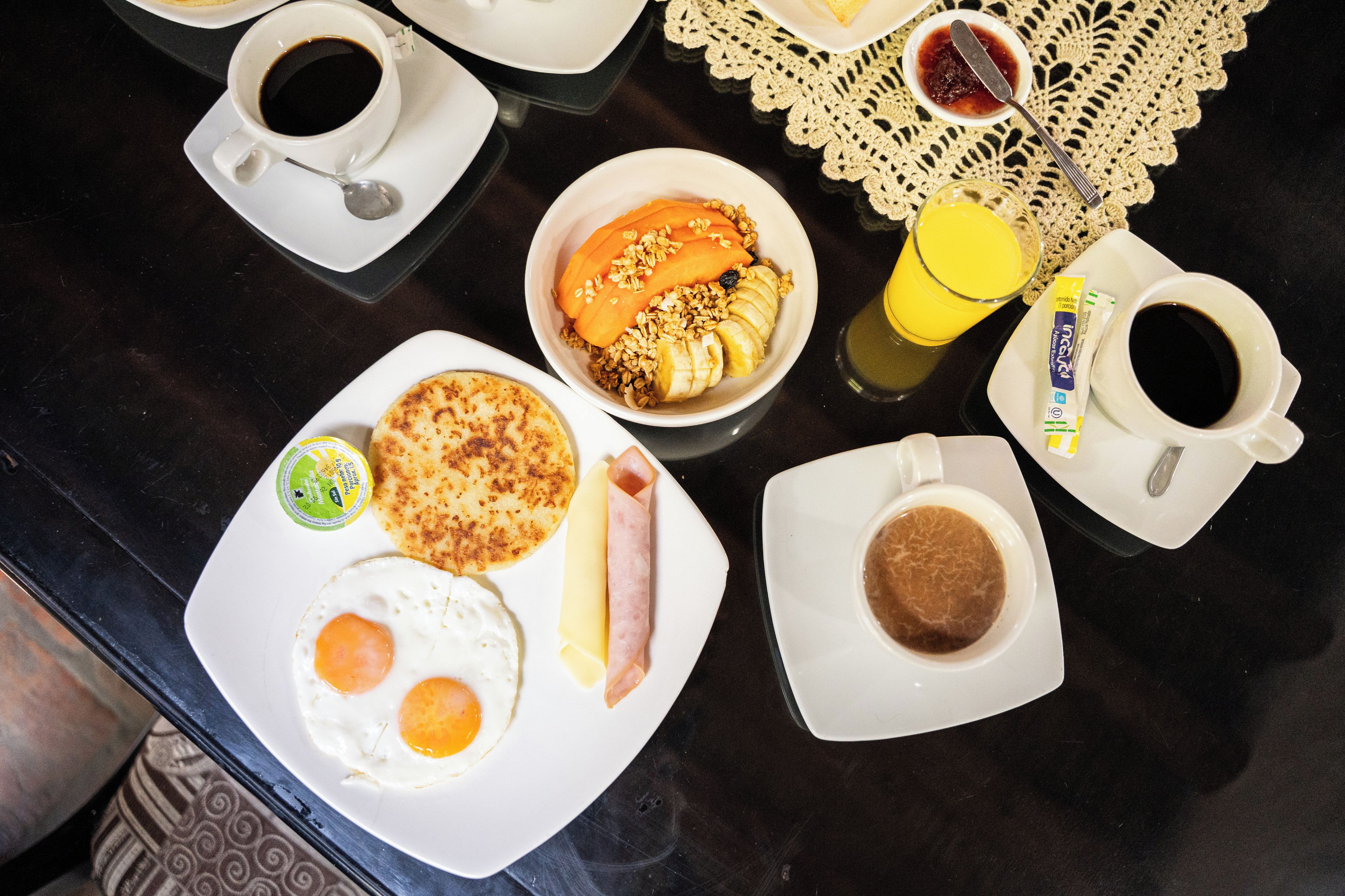 Una mesa de desayuno con diferentes alimentos y bebidas.