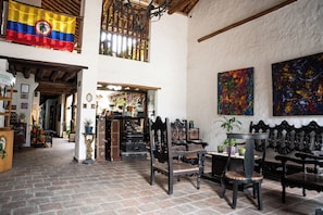 A spacious interior with high ceilings, a traditional wooden ceiling, and a mix of modern and classic furnishings. - Hotel Boutique Macaregua Giron (Giron)