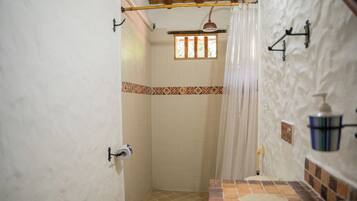 A bathroom with a shower, toilet, and a sink.