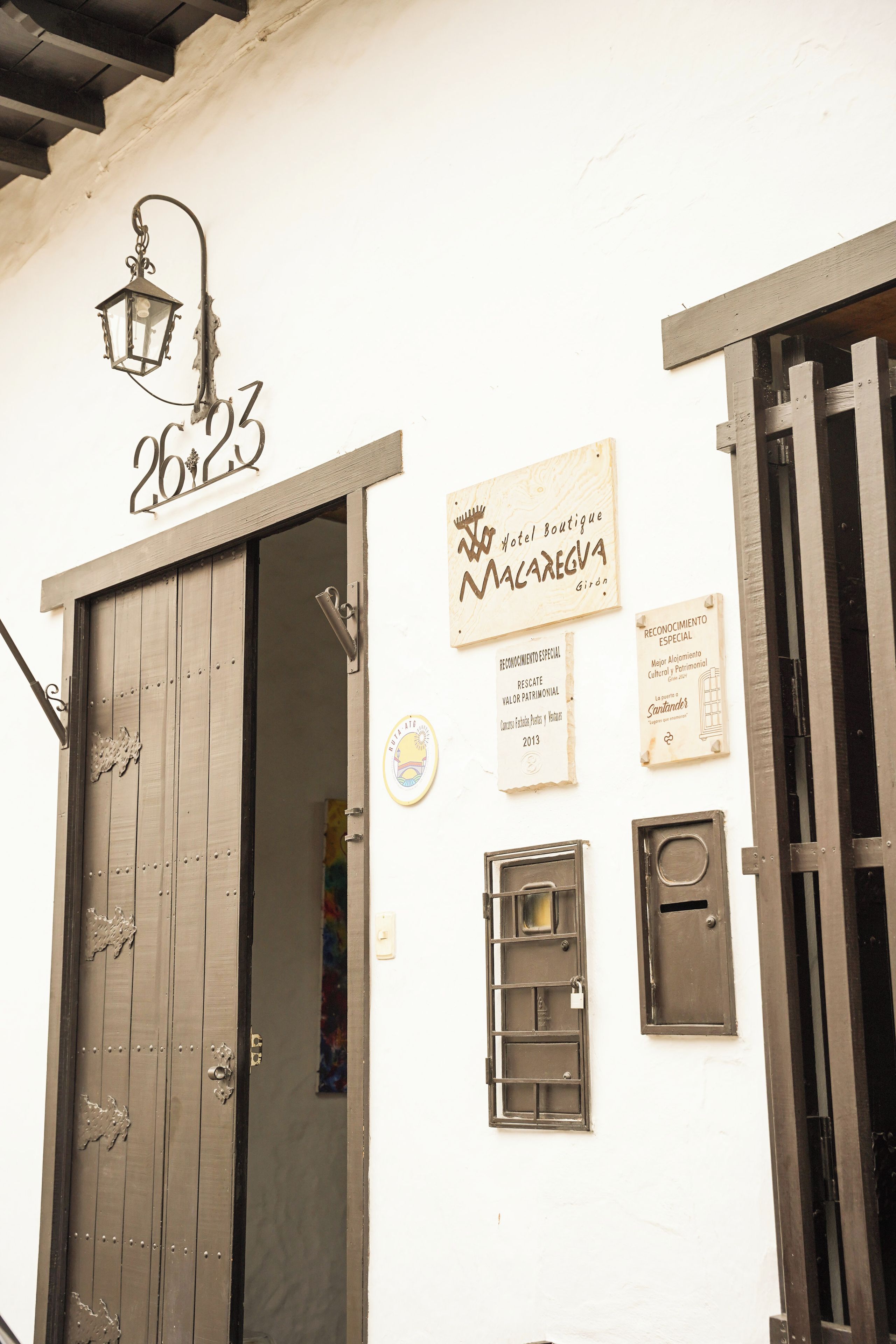 A building with a large wooden door, a sign above the door, and several smaller signs on the wall.