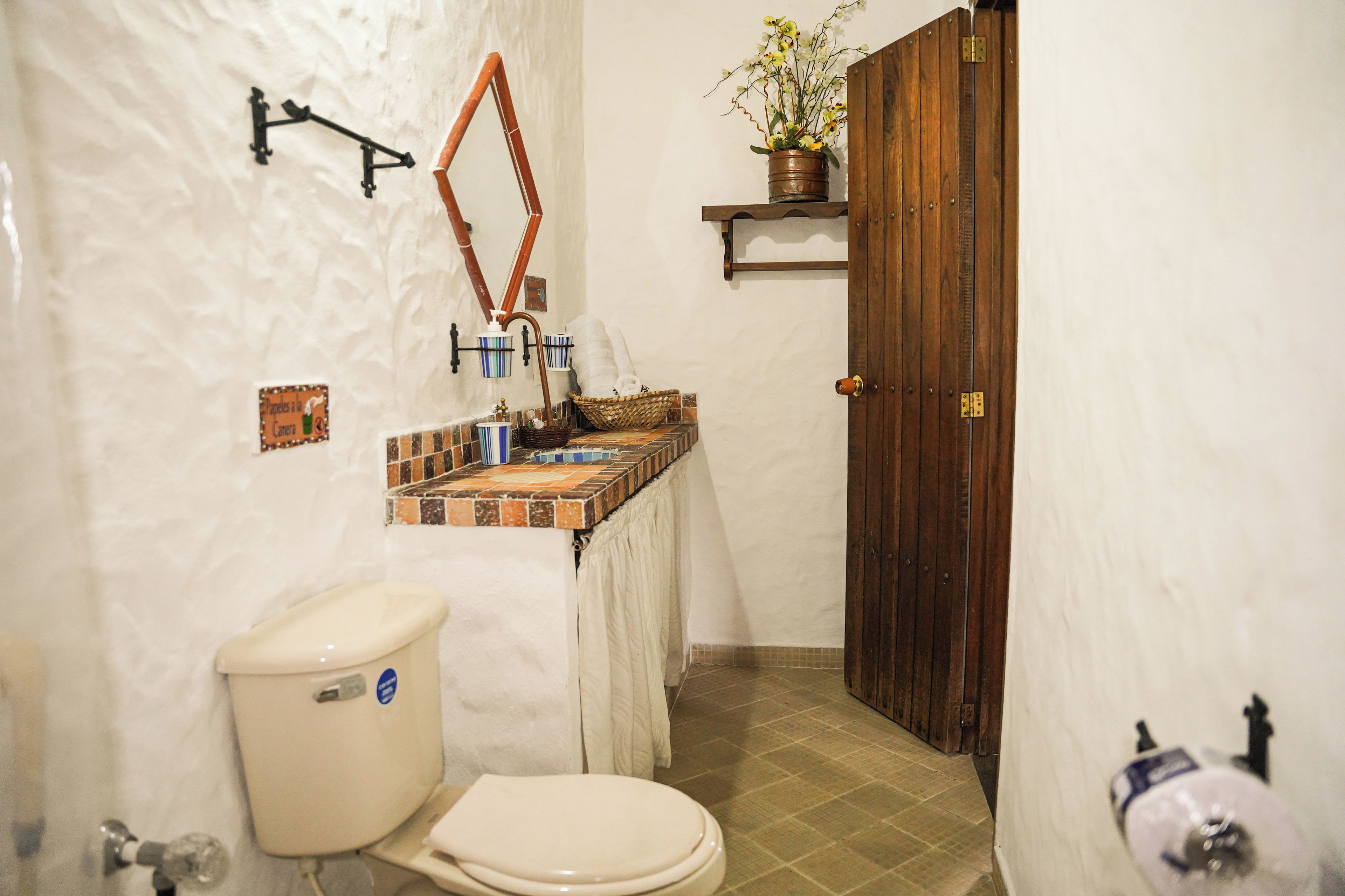 A bathroom with a toilet, sink, and shower area.