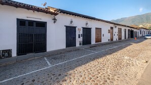 A cobblestone street lined with traditional buildings, each with a distinct door and window design.