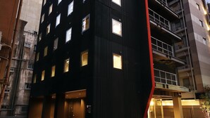A modern building with multiple floors, large windows, and a prominent red accent on the corner. - FL Hotel Dotonbori (Osaka)