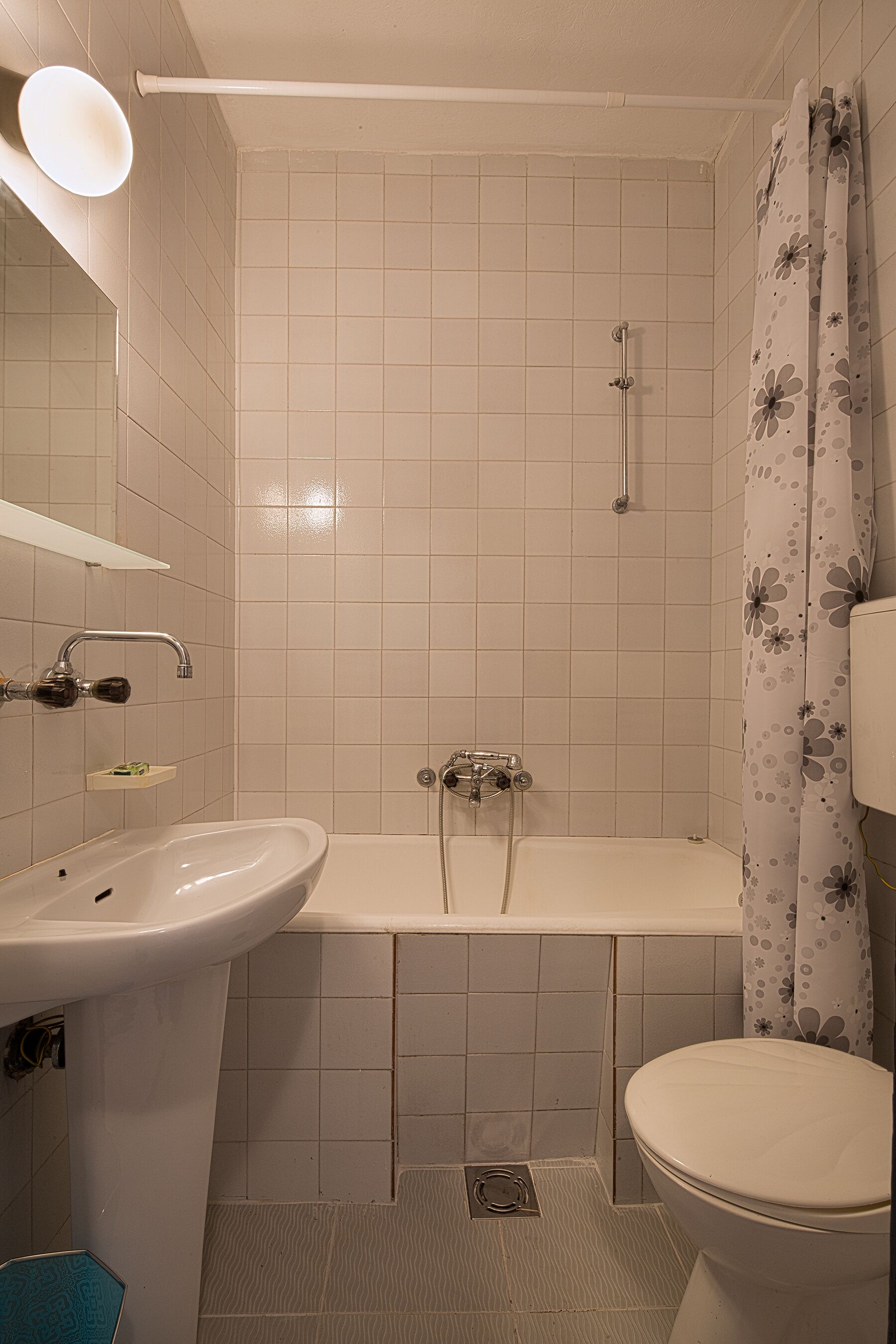 Un baño con lavamanos, inodoro y ducha.