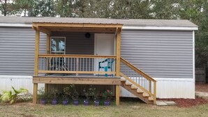 A single-story house with a wooden deck and a staircase leading to a covered porch. - 1/2 acre Private Fenced Dog Friendly (Navarre)