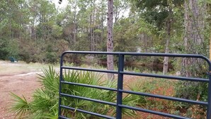 A fenced area with a dirt path leading to a bench. - 1/2 acre Private Fenced Dog Friendly (Navarre)