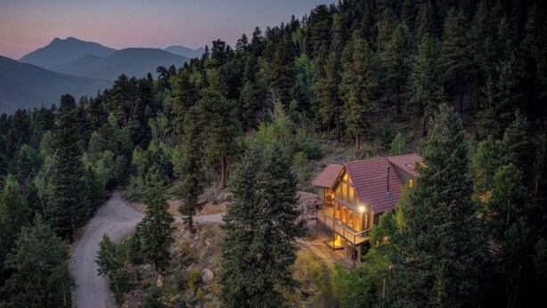 A cabin surrounded by dense forest with a clear road leading to it. - Mountain Retreat with Hot Tub Near State Park (Golden)