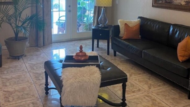 Ein Wohnzimmer mit einer Chandelier, einem Sofa, einem Couchtisch und einem Gemälde an der Wand.