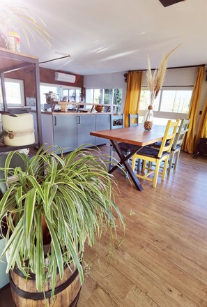 A spacious kitchen with modern appliances, wooden cabinets, and a dining area with a wooden table and chairs.