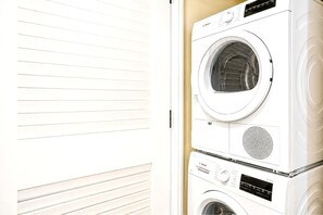 A stacked washer and dryer unit with a control panel and a vent.