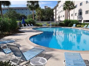 Relax by the pool surrounded by lush greenery and comfortable lounge seating.