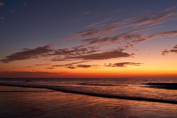 Enjoy a serene beach experience with the ocean gently lapping onto the shore.