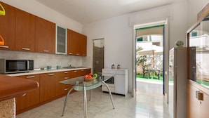 Una cocina moderna con armarios de madera, una mesa de vidrio y vistas al área exterior.