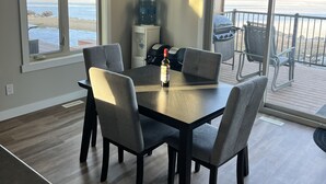 A dining area with a table and chairs, a water dispenser, and a grill.