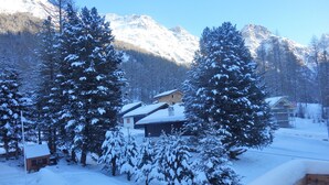 Un paisaje montañoso cubierto de nieve con cabañas de madera y árboles.