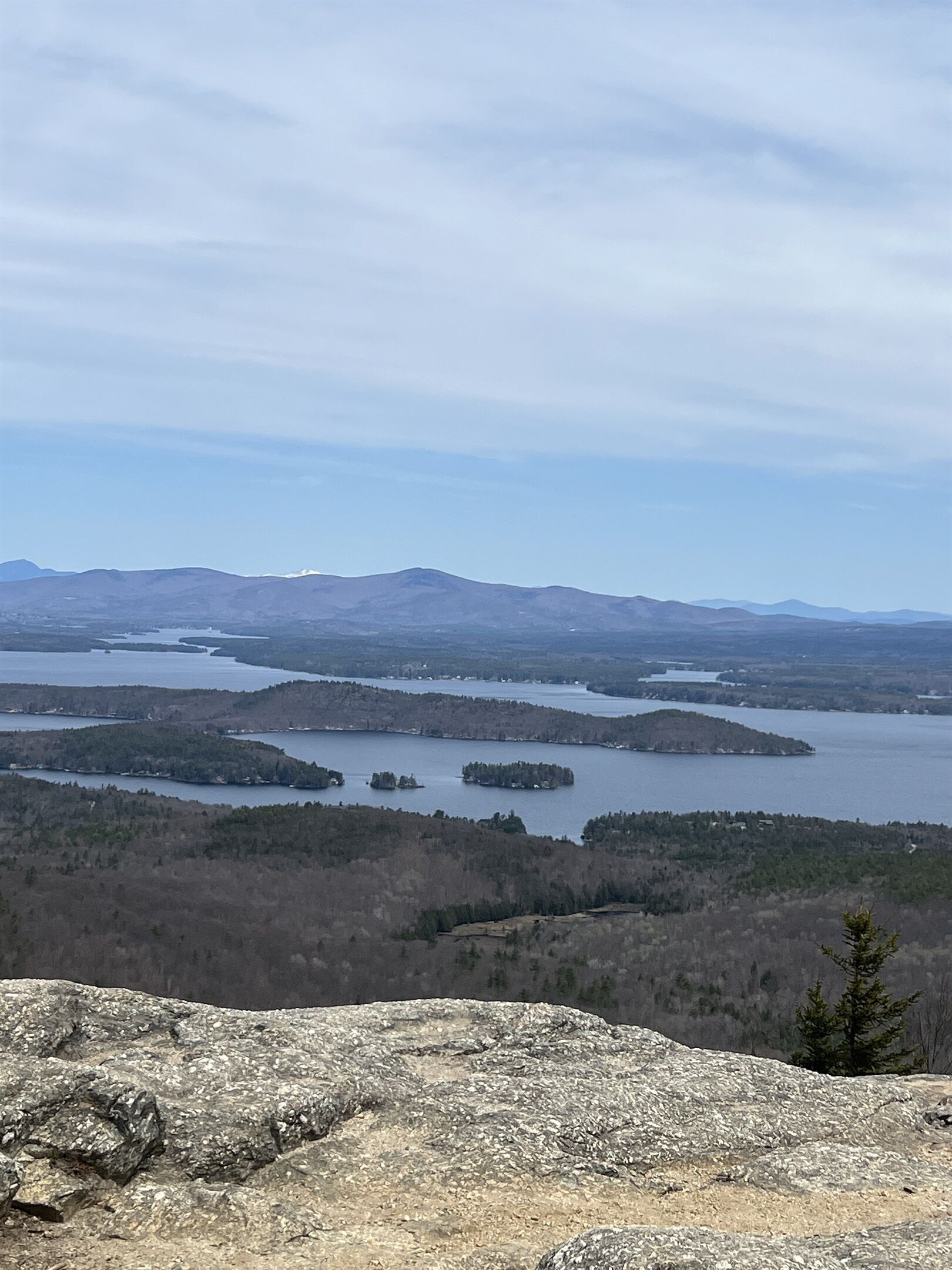 Ein weiter Blick auf eine Berglandschaft mit einem See und bewaldeten Gebieten.
