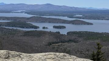 Vista panoramica di un paesaggio montuoso con un lago e zone boschive.