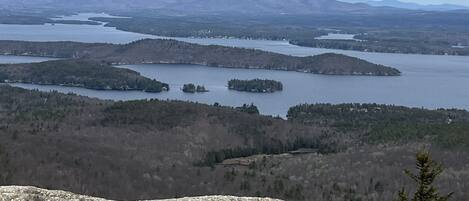 Ein weiter Blick auf eine Berglandschaft mit einem See und bewaldeten Gebieten.