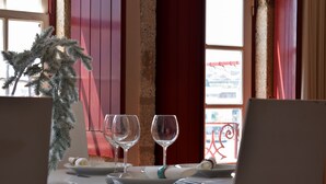 A dining table set with plates, cutlery, and two wine glasses, with a decorative plant to the left. - Apartment with 2 bedrooms, balcony and river view - 4th floor Registration no. 5848/AL (Porto)