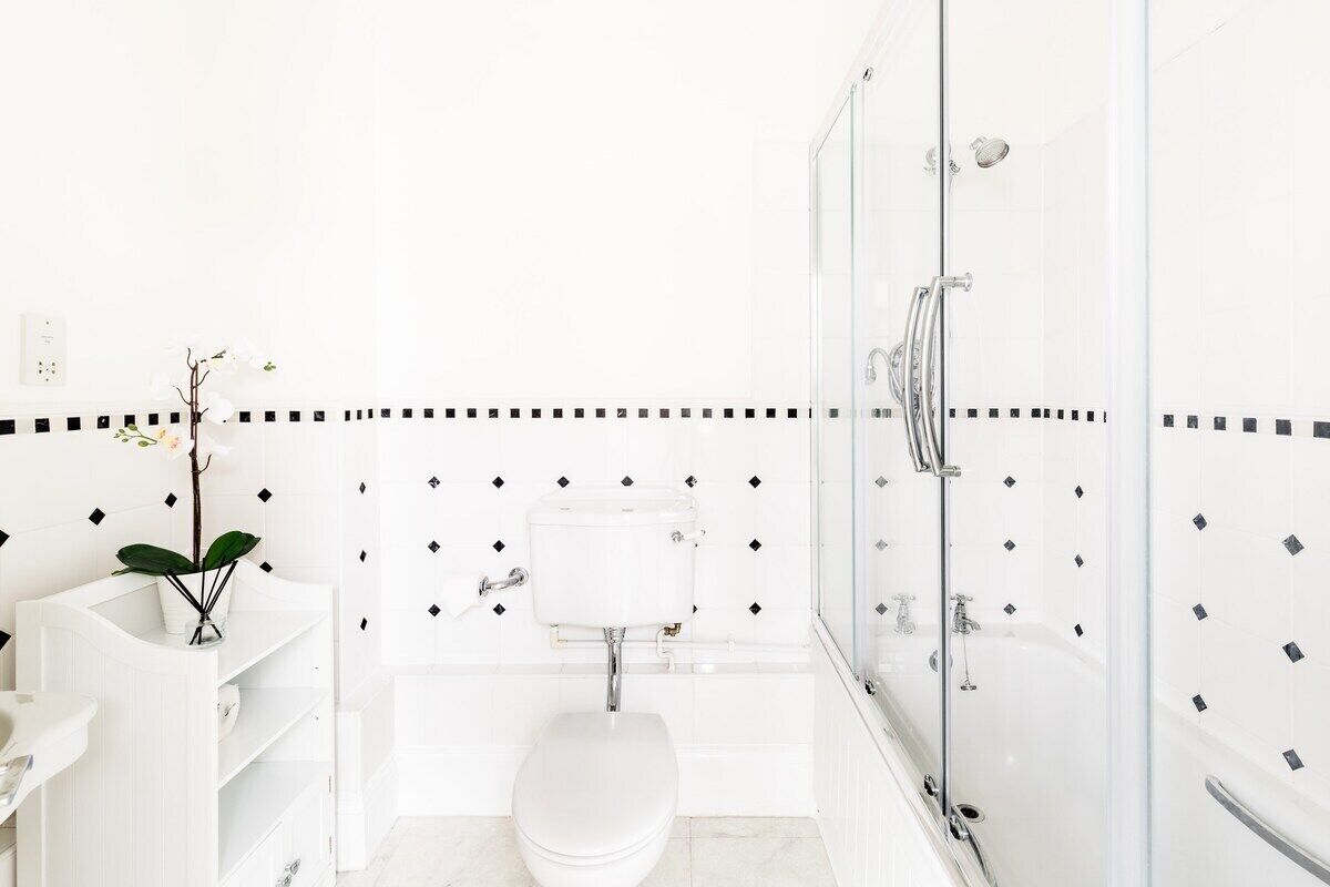 A modern bathroom with a toilet, sink, and shower.