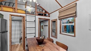 Una cocina compacta con una mesa de madera, estufa integrada y ventana con vistas al exterior.