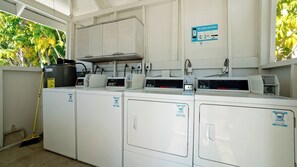 A laundry facility with industrial washing machines and a commercial dryer.