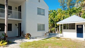 A two-story building with a balcony and a small attached structure.