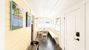 Un couloir avec un banc, une porte et des œuvres d’art mural.