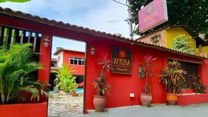 A red building with a sign reading "AFRIKA Pousada." - Pousada Afrika (Ipojuca)